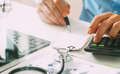 Image of healthcare provider writing with a pen